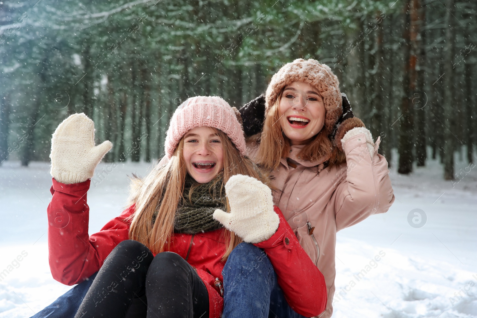 Photo of Mother and daughter having fun in forest on snow day