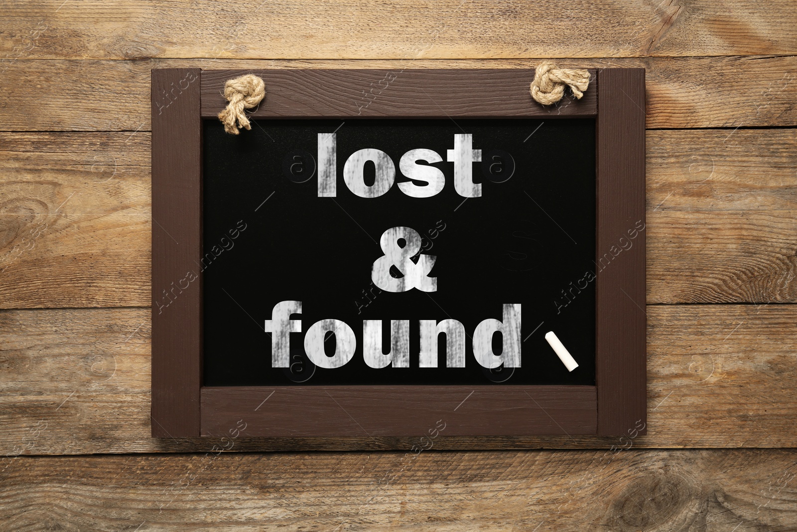 Image of Phrase Lost and Found written on blackboard on wooden table, top view