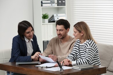 Professional notary working with couple in office