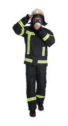 Photo of Full length portrait of firefighter in uniform, helmet and gas mask on white background