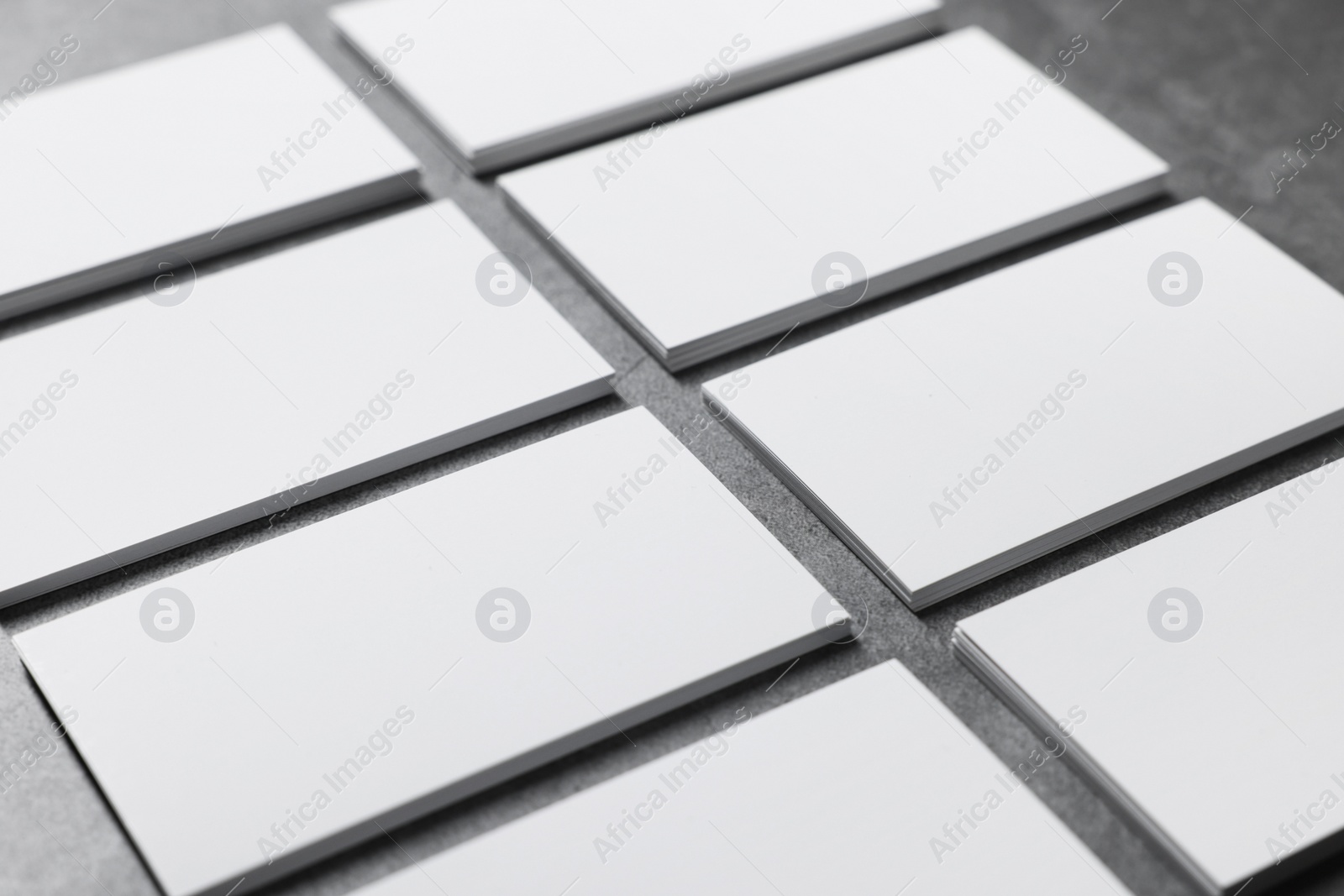 Photo of Blank business cards on grey textured table, closeup. Mockup for design