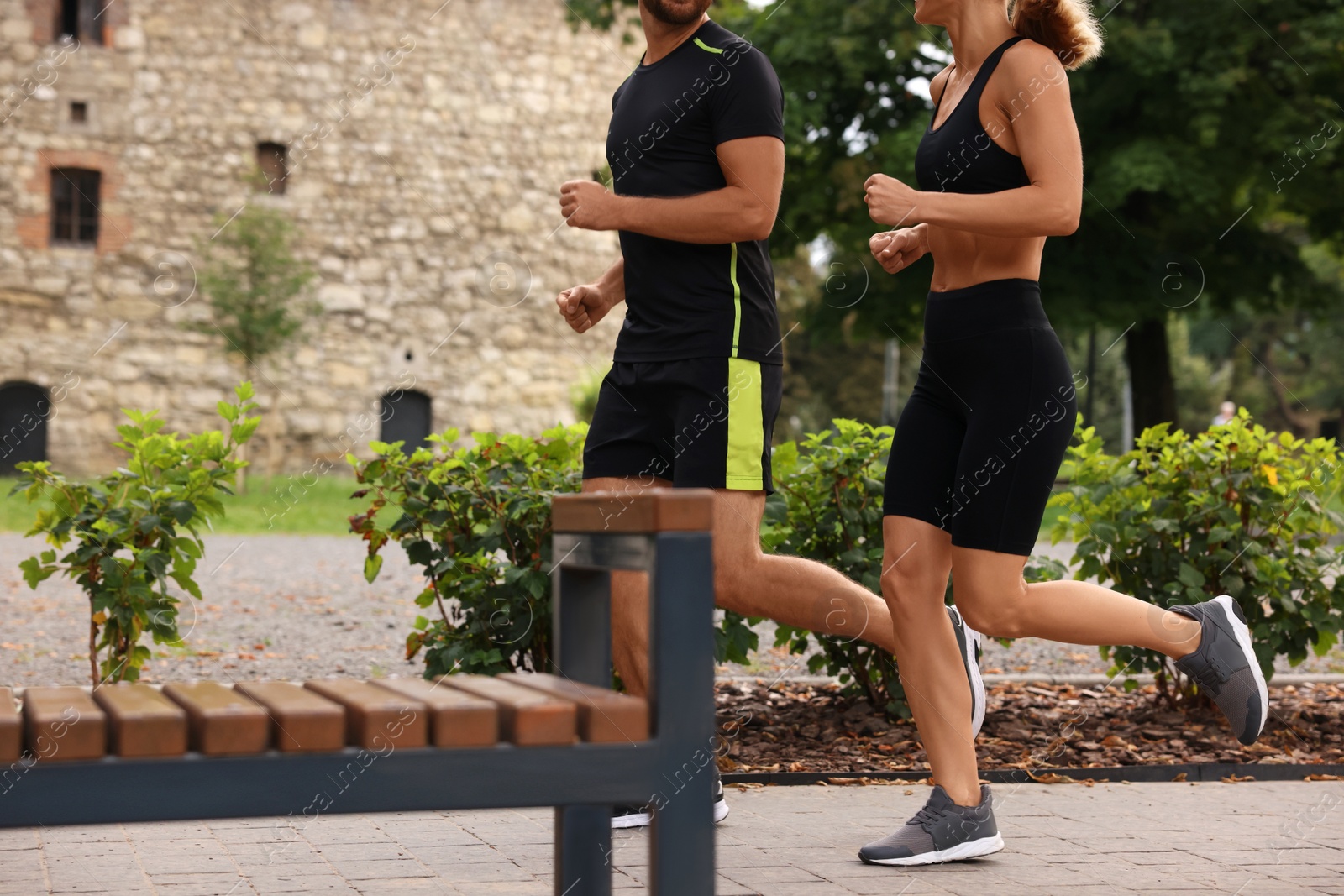 Photo of Healthy lifestyle. Couple running in park, closeup with space for text