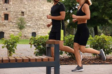 Photo of Healthy lifestyle. Couple running in park, closeup with space for text