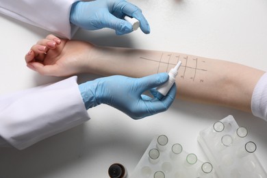 Photo of Doctor doing skin allergy test at light table, top view