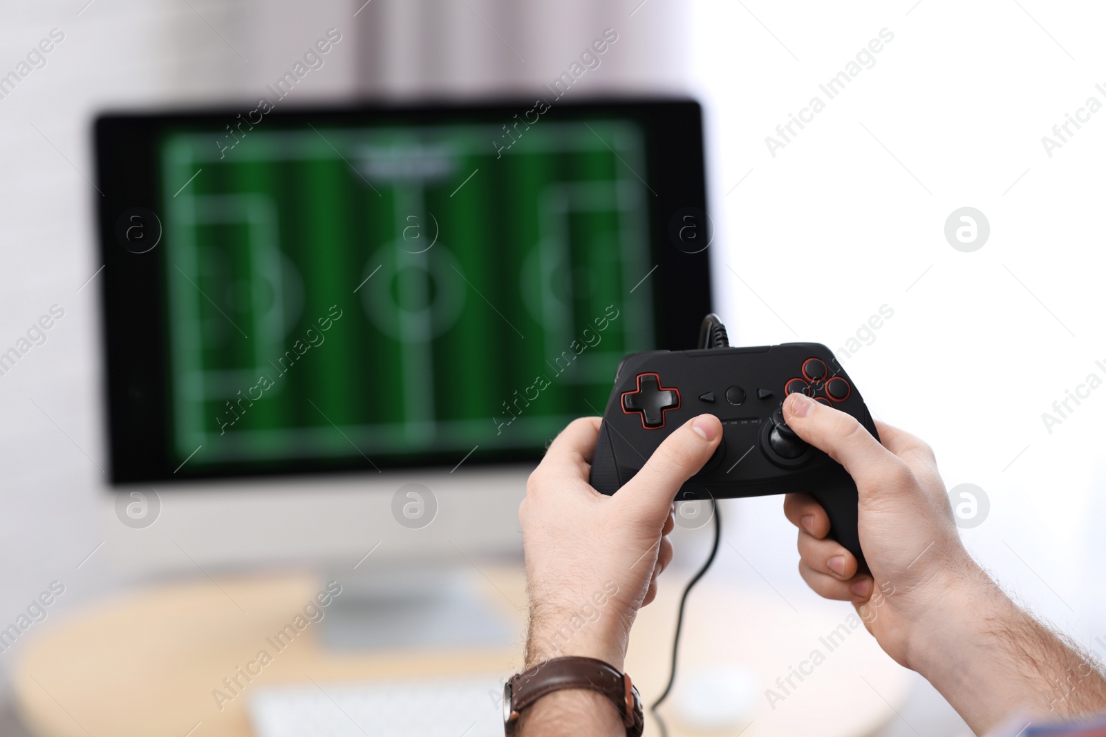 Photo of Young man playing video game at home, closeup