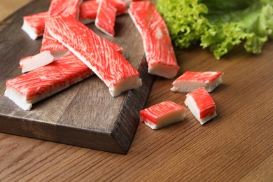 Delicious crab sticks on wooden table, closeup