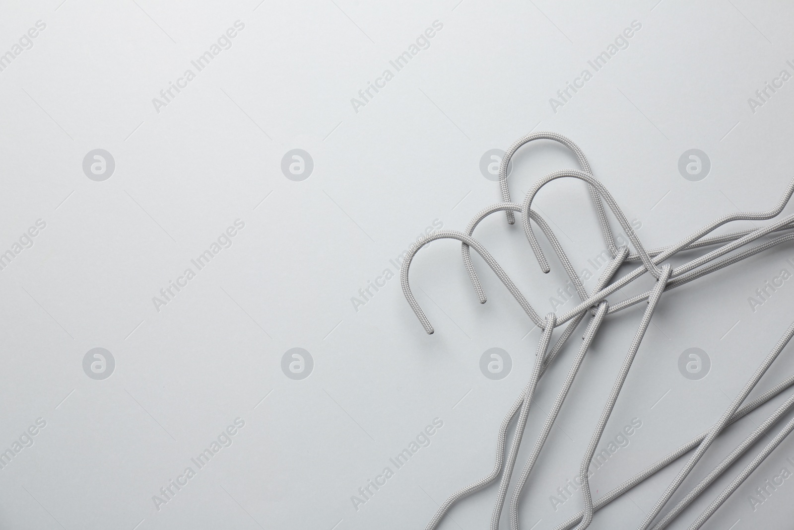 Photo of Hangers on light gray background, top view. Space for text