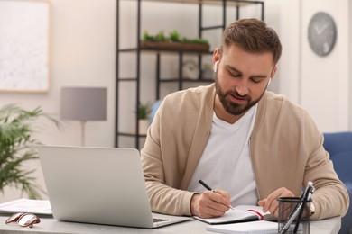 Young man with earphones working at home