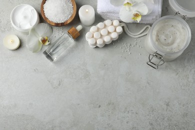 Photo of Flat lay composition with different spa products and burning candles on light grey table. Space for text