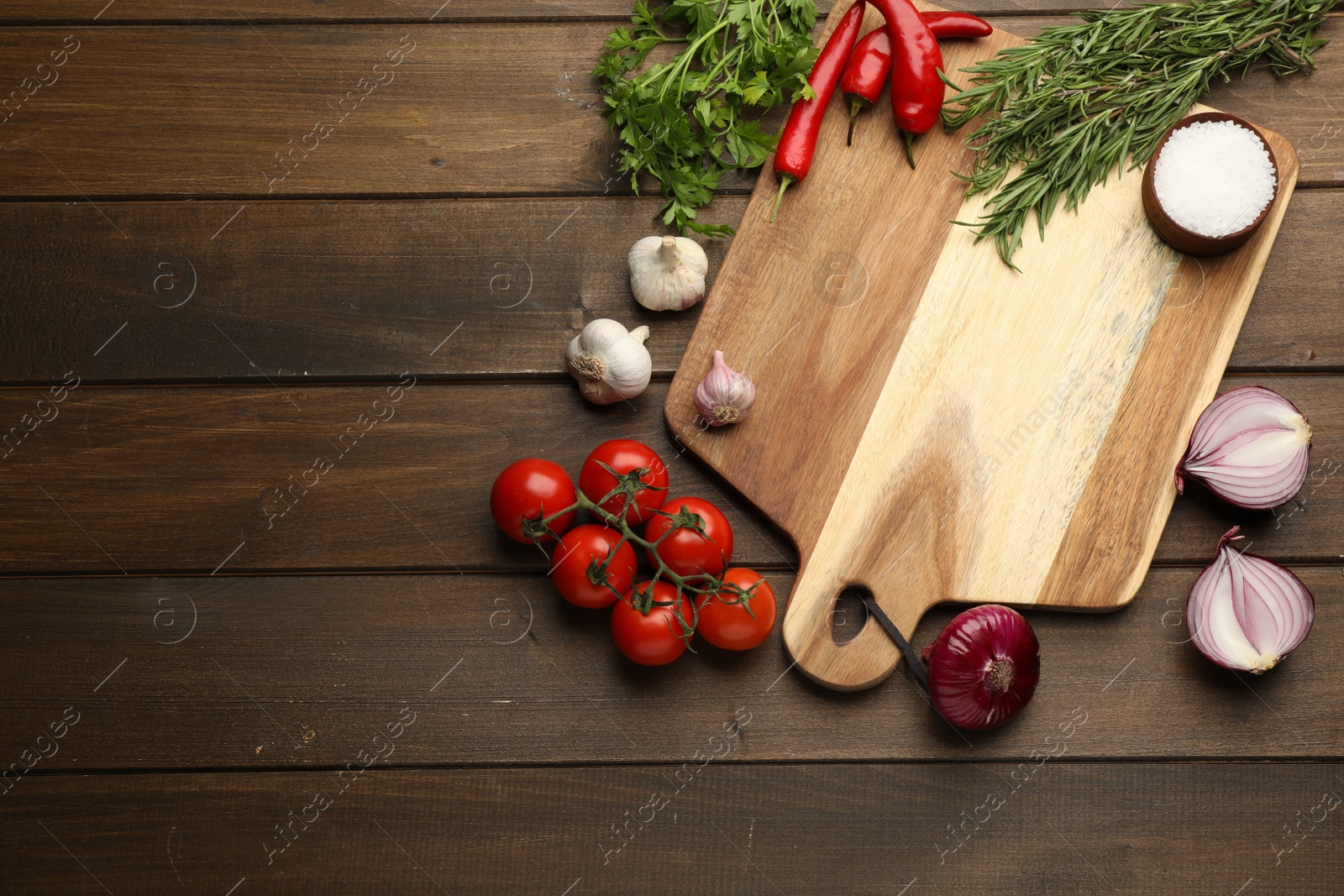 Photo of Cutting board and vegetables on wooden table, flat lay with space for text. Cooking utensil