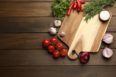 Photo of Cutting board and vegetables on wooden table, flat lay with space for text. Cooking utensil