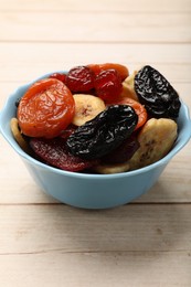 Photo of Mix of delicious dried fruits on white wooden table, closeup