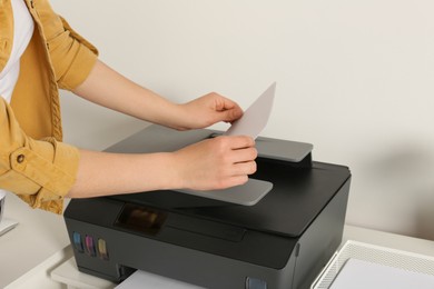 Woman using modern printer at home, closeup