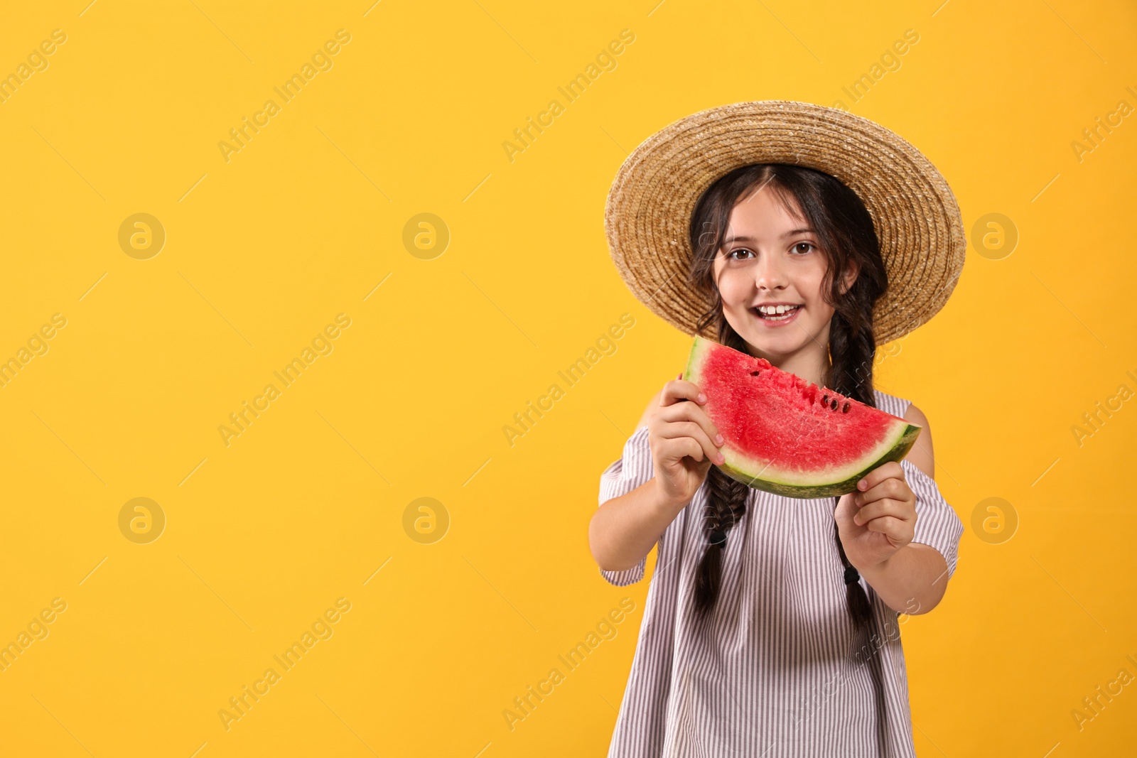 Photo of Cute little girl with watermelon on yellow background. Space for text