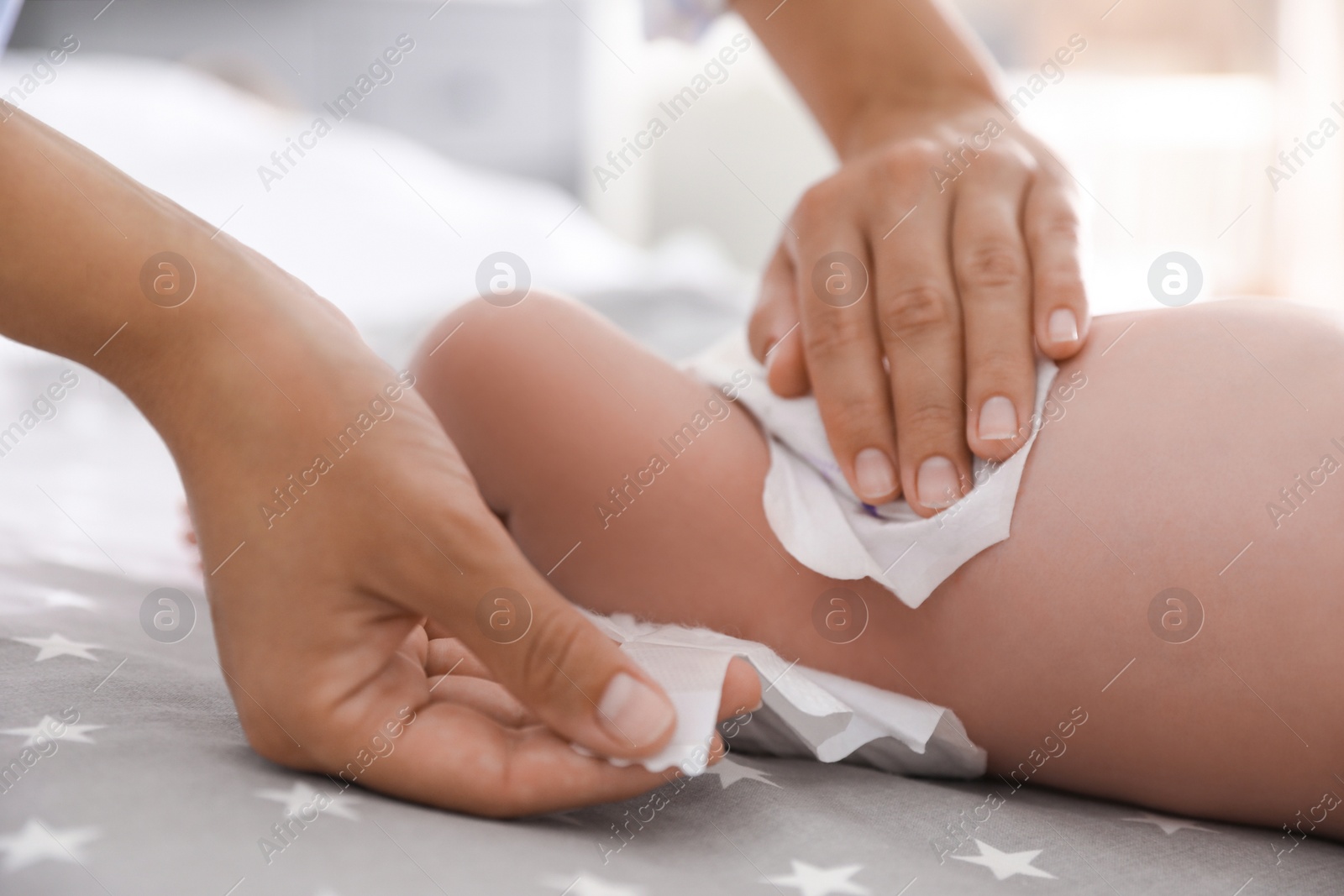 Photo of Mother changing her baby's diaper on bed, closeup