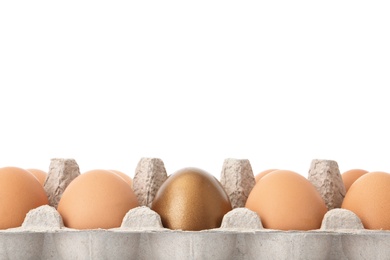 Photo of Eggs with golden one in carton on white background