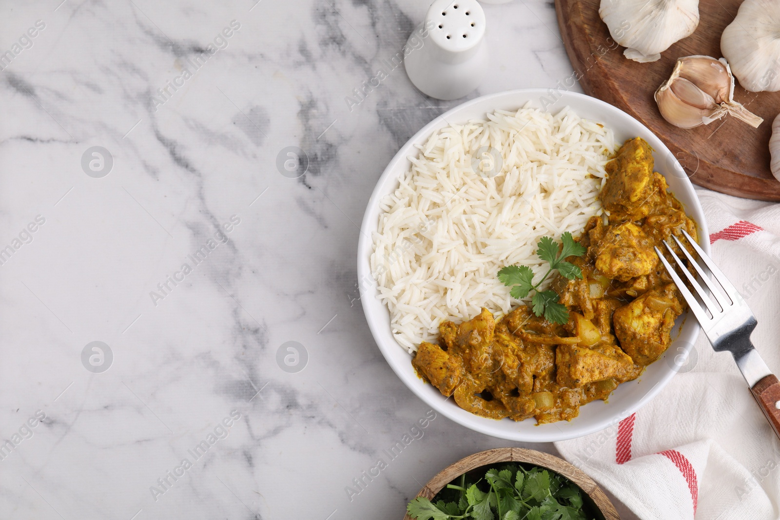 Photo of Delicious chicken curry with rice and ingredients on white marble table, flat lay. Space for text