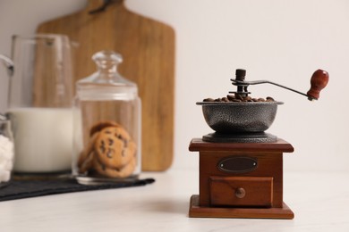 Photo of Vintage manual coffee grinder with beans on counter in kitchen