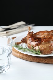 Tasty cooked rabbit meat with rosemary on white wooden table