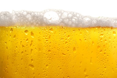 Photo of Glass of tasty cold beer with foam and condensation drops on white background, closeup