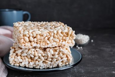 Photo of Delicious rice crispy treats on grey table, closeup