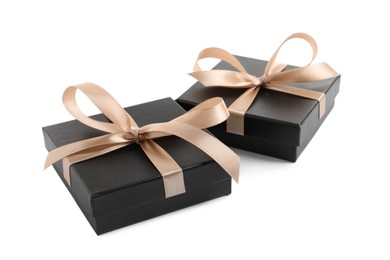 Photo of Dark gift boxes with golden bows on white background