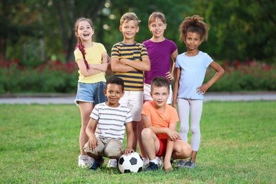 Cute little children with soccer ball in park. Outdoor play