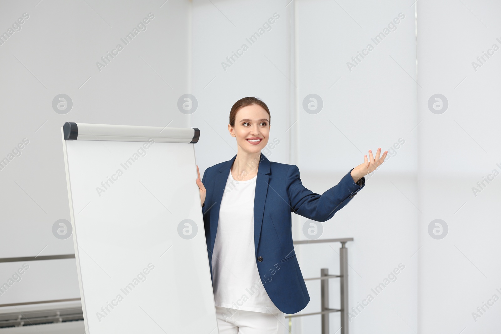 Photo of Professional business trainer near flip chart board indoors. Space for text