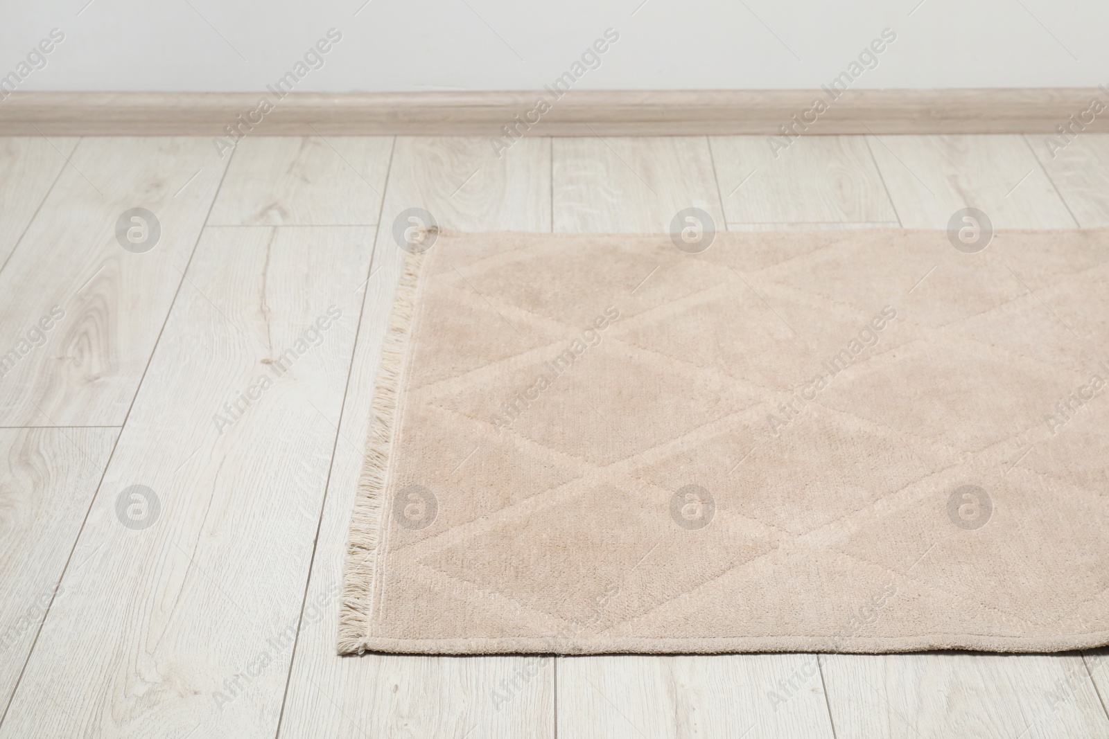 Photo of Soft beige carpet on white laminated floor indoors