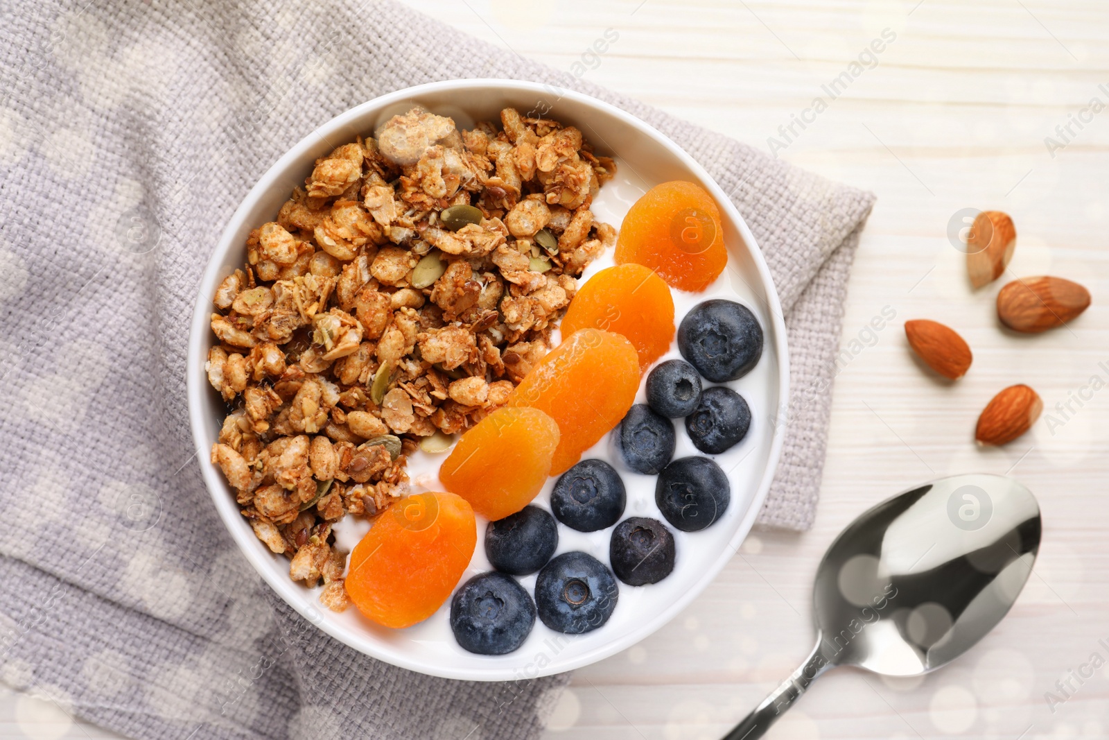 Photo of Delicious granola with fruits on white wooden table, flat lay