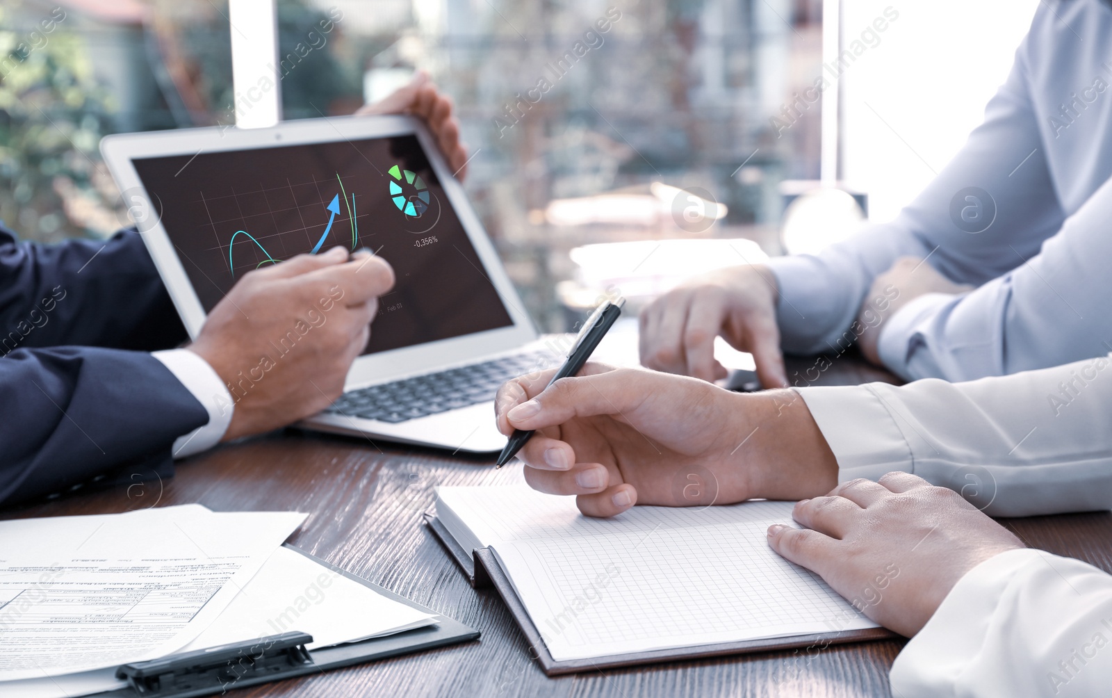 Image of Brokers working with clients at table in office, closeup. Forex trading