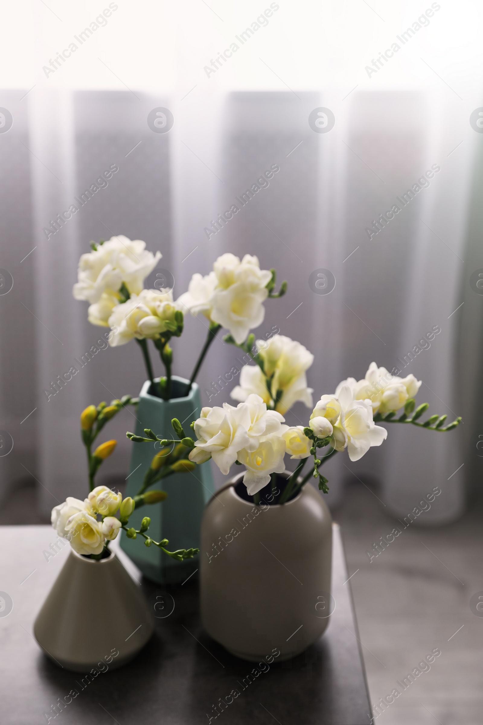 Photo of Beautiful spring freesia flowers on table in room