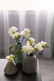 Photo of Beautiful spring freesia flowers on table in room