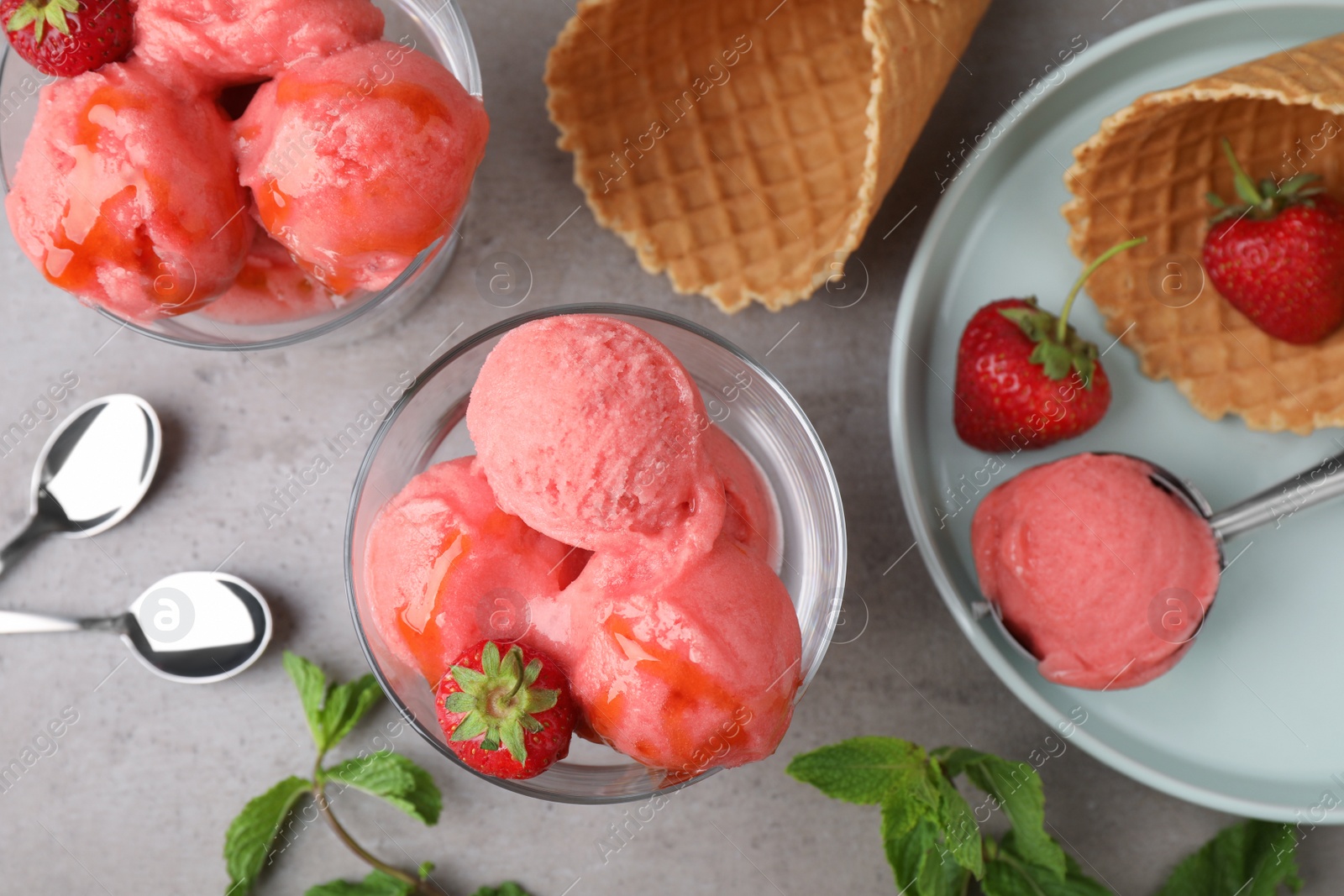 Photo of Flat lay composition with pink ice cream, mint and strawberries on grey table