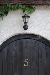 House number five on wooden door outdoors
