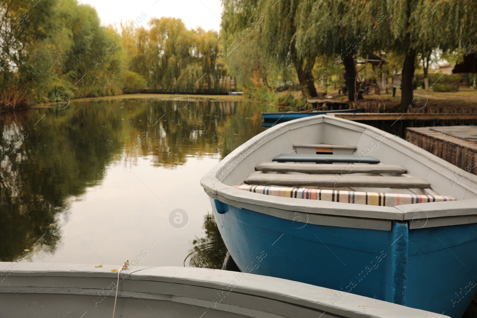 Photo of Light blue wooden boat on lake, space for text