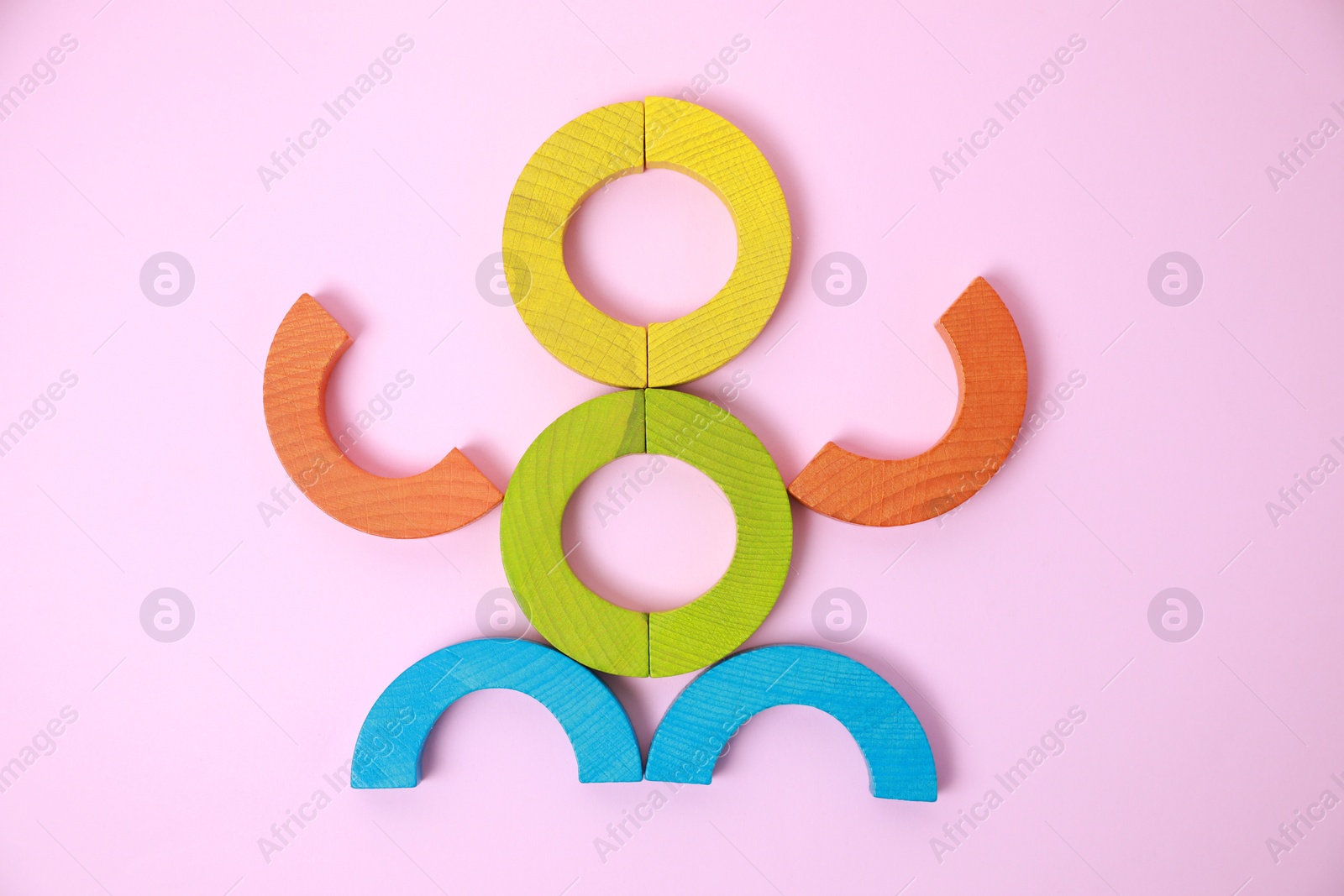 Photo of Colorful wooden pieces of playing set on pink background, flat lay. Educational toy for motor skills development