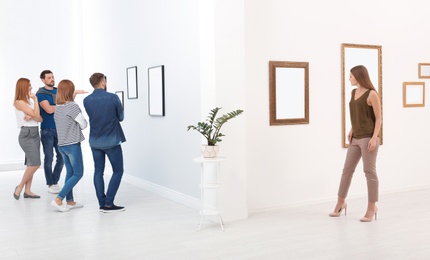 Photo of People viewing exposition in modern art gallery