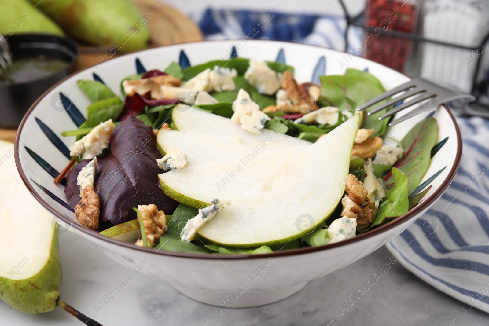 Photo of Delicious pear salad in bowl on marble table, closeup