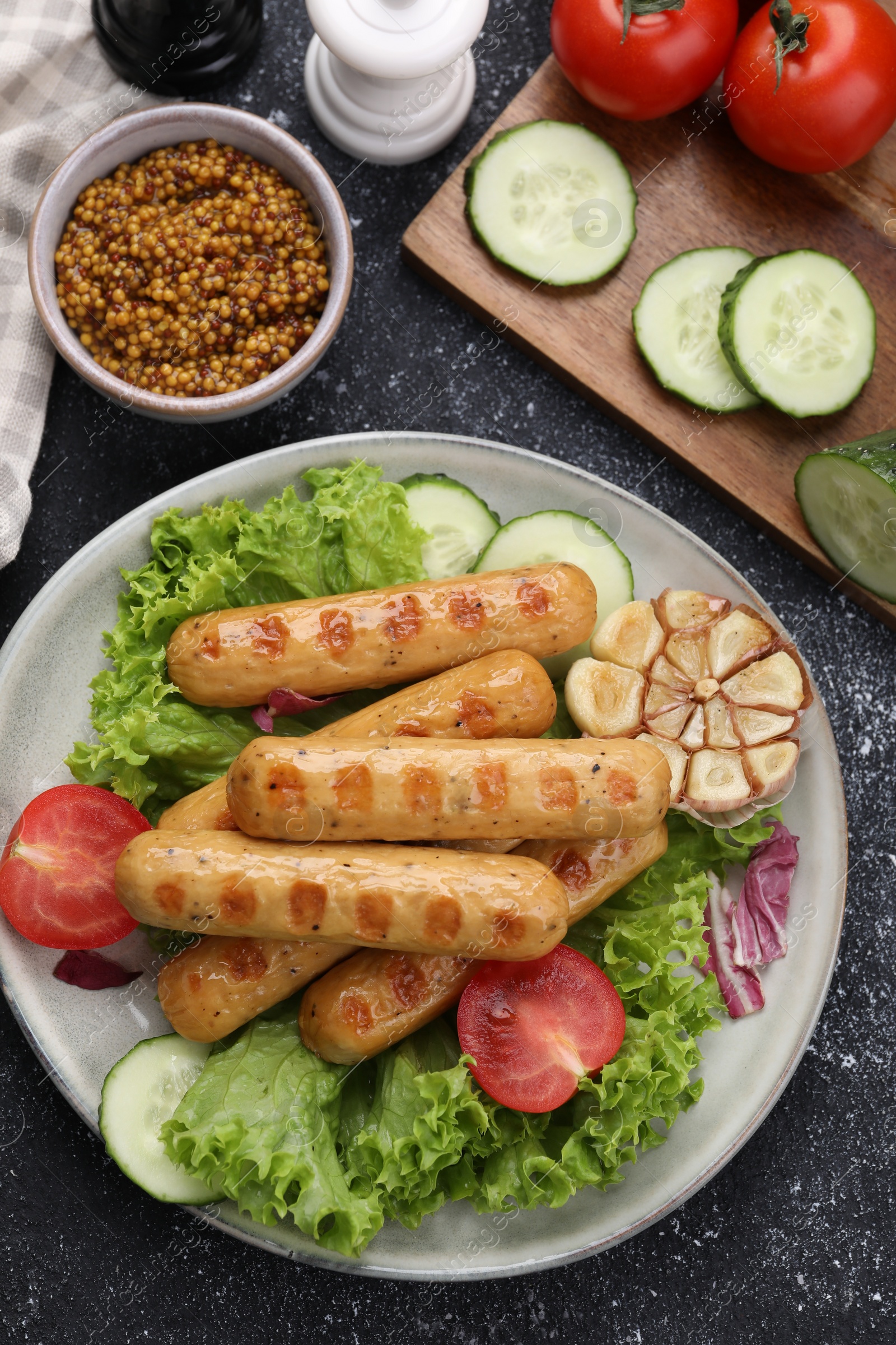 Photo of Delicious grilled vegan sausages with fresh herbs and vegetables on grey table, flat lay