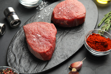 Photo of Fresh raw beef cut on black table, closeup