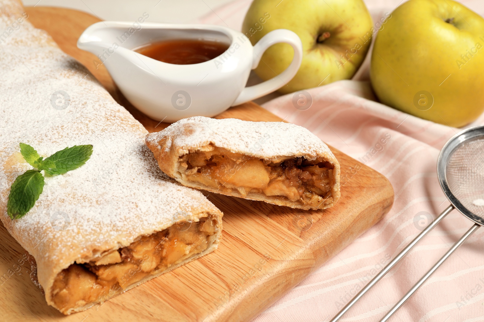 Photo of Delicious strudel with apples and nuts served on table, closeup