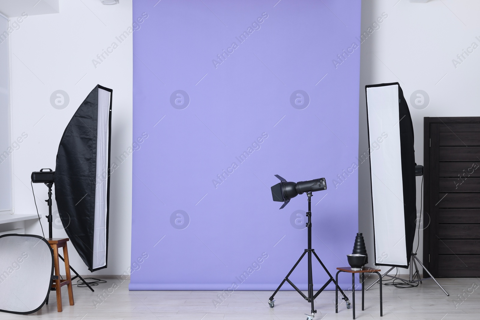 Photo of Violet photo background and professional lighting equipment in studio