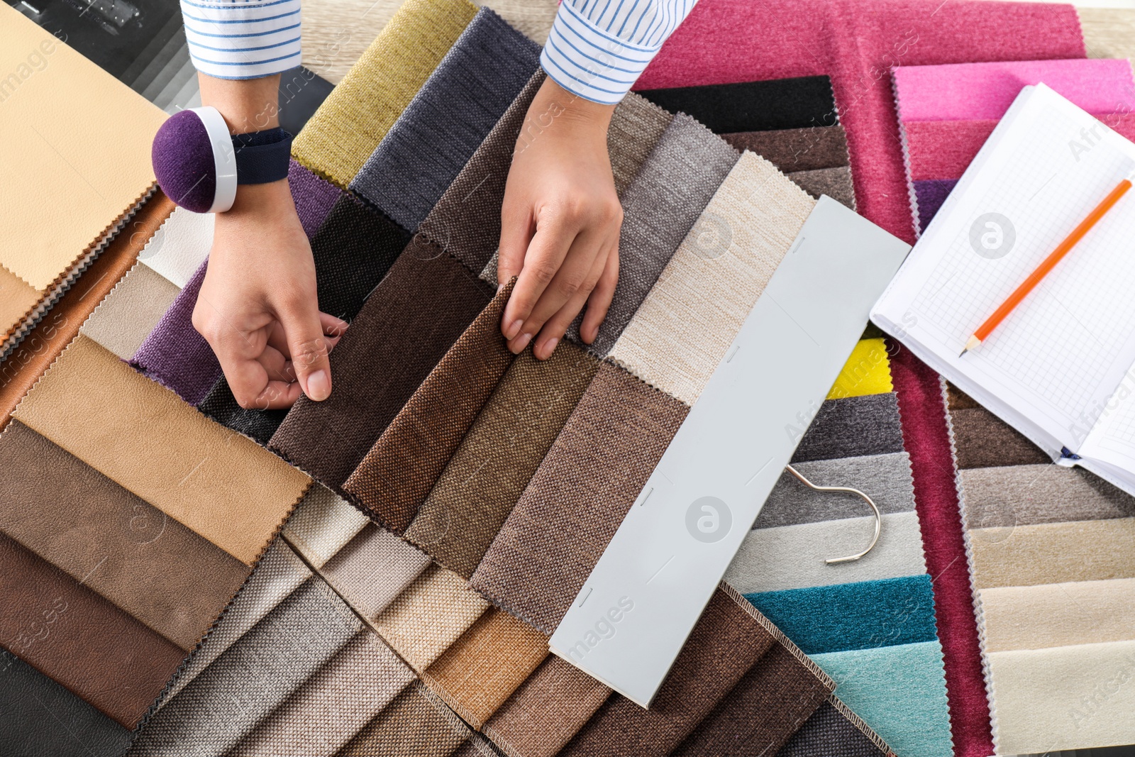 Photo of Young woman choosing among upholstery fabric samples, closeup. Interior design