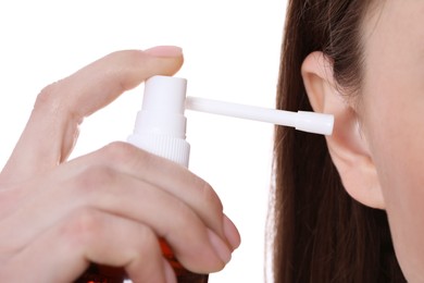 Photo of Woman using ear spray on white background, closeup