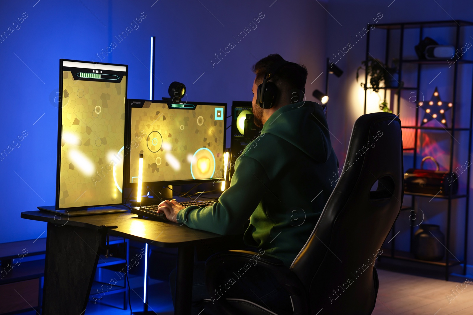 Photo of Man playing video games on computer at table indoors