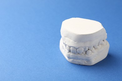 Photo of Dental model with gums on blue background, space for text. Cast of teeth