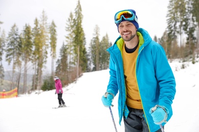 Photo of Male skier on slope at resort, space for text. Winter vacation