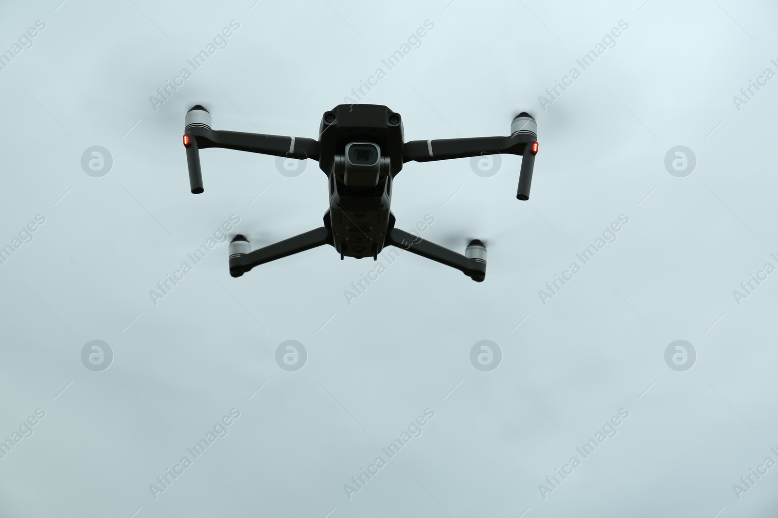 Photo of Modern drone against cloudy sky, low angle view