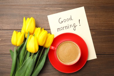 Photo of Beautiful yellow tulips, cup of aromatic coffee and Good Morning note on wooden table, flat lay